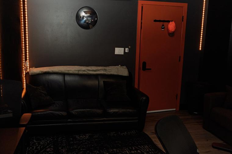 Room A lounge with leather couch and red studio door